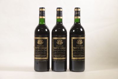trois bouteilles de vin posées l'une à côté de l'autre sur une table