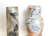 two vases sitting next to each other on a white surface