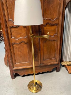 une lampe posée sur un pied devant une armoire