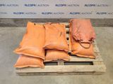 several bags of sand sit on a pallet in front of a wall