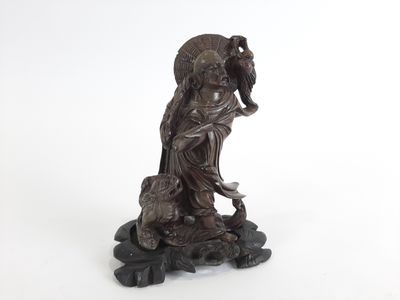 une vieille statue en bronze représentant une femme avec un oiseau sur l'épaule