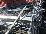 a large pile of metal equipment sitting in front of a red container