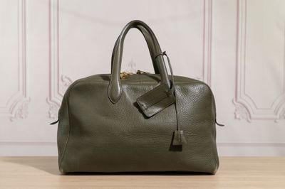 a green handbag sitting on top of a wooden table