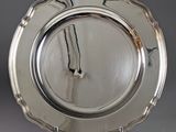 a silver plate with a clock on it on a stand