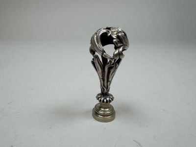 a silver figurine of a bird on a pedestal