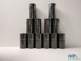 several black cans stacked on top of each other on a white surface