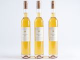 three bottles of wine sitting next to each other on a white surface