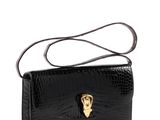 a black crocodile skin purse with a gold skull on the front