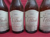 four bottles of beer are lined up in a row on a red background