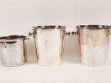 three silverplated ice buckets with handles on a white background