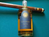 une bouteille d'alcool et un cigare posés sur une table de billard