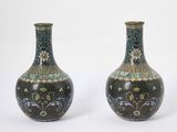two vases sitting side by side on a white surface