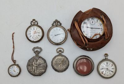 many different types of pocket watches displayed on the table