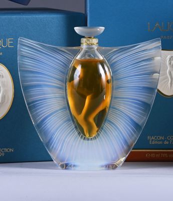 a bottle of perfume with a picture of a woman on it next to a box