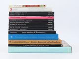 plusieurs livres empilés sur une surface blanche