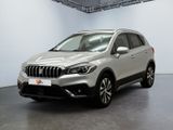 Le SUV argenté est garé dans une pièce blanche au sol noir.