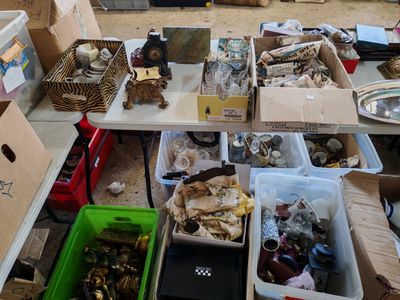 Des cartons contenant divers objets sont posés sur une table dans une pièce