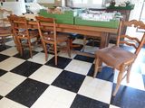 une table et des chaises dans une pièce dont le sol est en damier noir et blanc