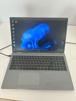 un ordinateur portable ouvert posé sur une table blanche