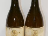 two bottles of wine sitting on top of a table next to each other
