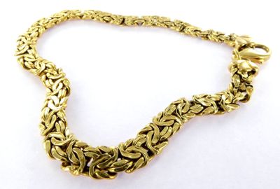 a close up of a gold chain bracelet on a white background