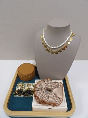 un collier, des bracelets et d'autres bijoux posés sur un plateau