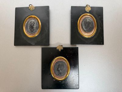 three black and gold medallions mounted on a white wall