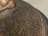 a close up of a bronze vase on a table