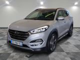 un SUV argenté garé sur un sol en damier dans un garage