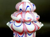 a white vase with red, white and blue swirls on it