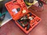 une boîte à outils rouge contenant des outils, posée par terre