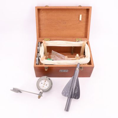 une boîte en bois contenant des outils, posée sur une surface blanche