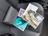 a car seat with a bunch of books and magazines in it