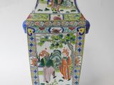 a vase with a painting on it sitting on a table