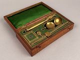 a small wooden box with a gold spoon and spoon rest in it