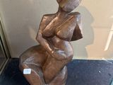 a statue of a woman sitting on top of a table