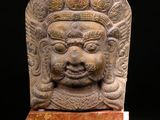 an image of a stone head on a wooden stand
