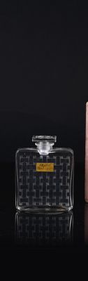 bottles of perfume on a black surface with a box in the background