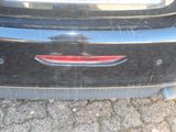 the rear end of a black car with a red tail light