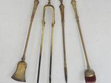 three antique brass brooms and a brush on a white surface