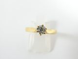 un gros plan d'une bague en or jaune sertie d'un diamant gris