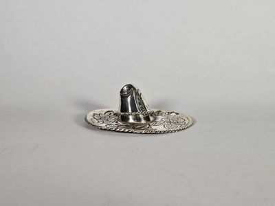 un gros plan sur une assiette en argent sur laquelle est posé un chapeau
