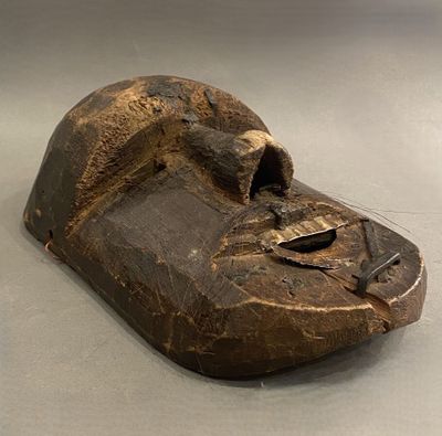 un masque en bois posé sur une table
