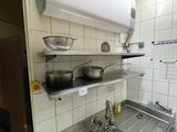 many pots and pans on the shelves in the kitchen