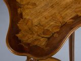 a close up of a wooden table with a leaf design on it