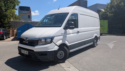 La camionnette blanche est garée sur le bord de la route, sur le parking.