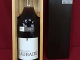 une bouteille de vin dans un coffret en bois sur fond rouge