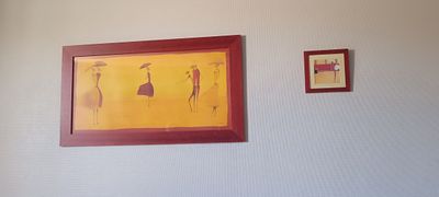 tableau accroché au mur d'une chambre où se trouvent un lit et un tableau accroché au mur