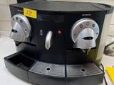 a black coffee machine sitting on a counter in a kitchen