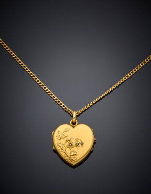a gold locke with a heart shaped locke on a chain